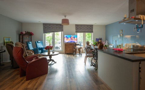 mevrouw zit in haar woonkamer