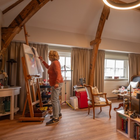 Mevrouw schildert in haar kamer