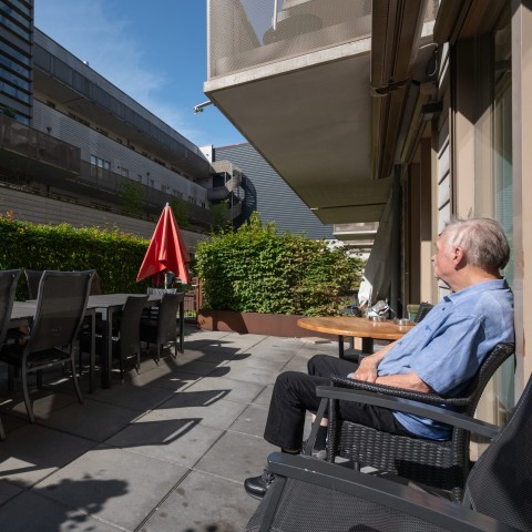 Meneer zit lekker buiten in het zonnetje