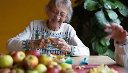 Mevrouw schilt lachend appels