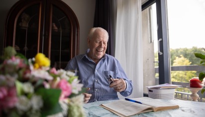 Meneer Wever met zijn boek aan tafel