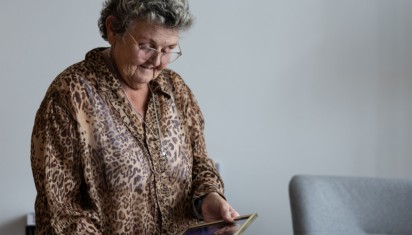 mevrouw kijkt blij naar haar fotolijstjes