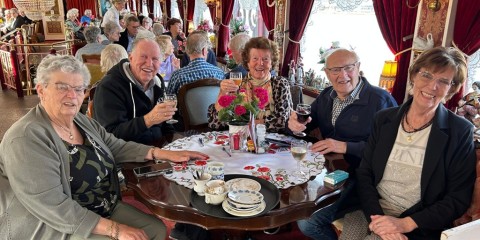 mensen zitten gezellig met elkaar aan tafel
