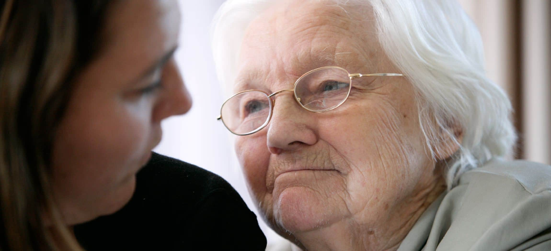 Close up oude vrouw grijs haar kijkt innig naar dochter