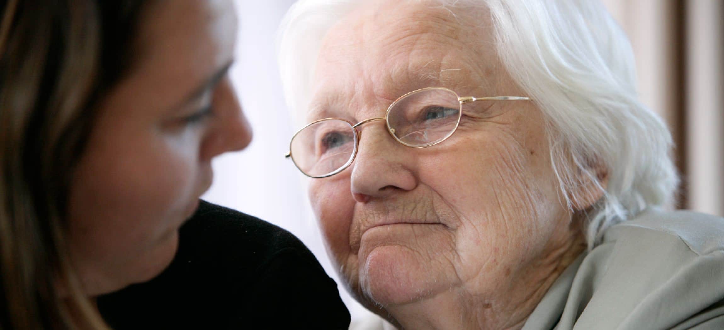 Close-up oude vrouw grijs haar kijkt met vertrouwen naar dochter