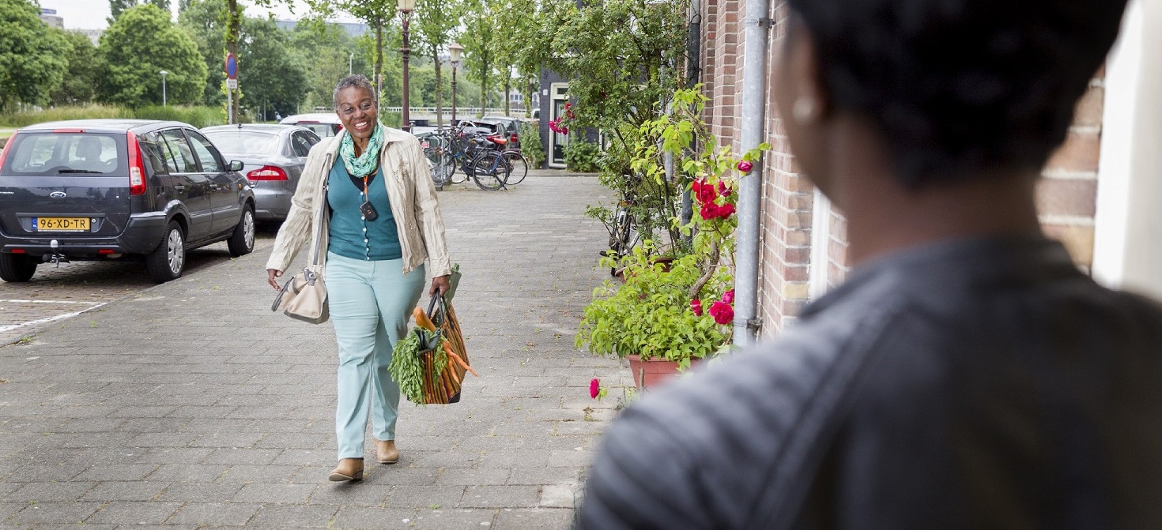 Vrouw loopt buiten met mobiele alarmknop