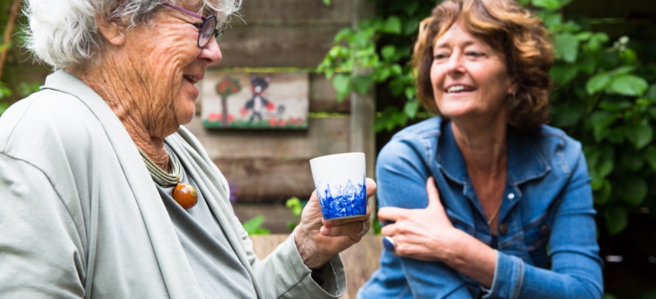 Twee oudere vrouwen in keuken met witte blouses