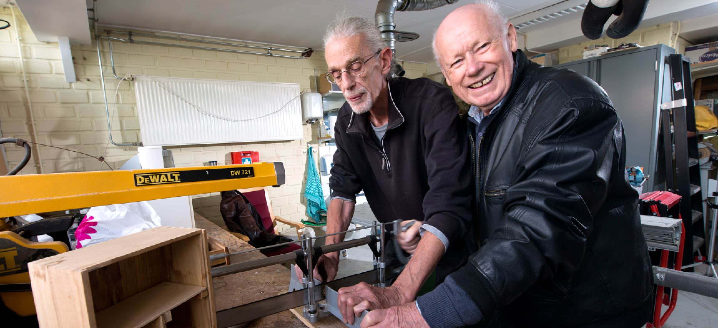 Twee oudere mannen in doe-het-zelf timmer werkplaats