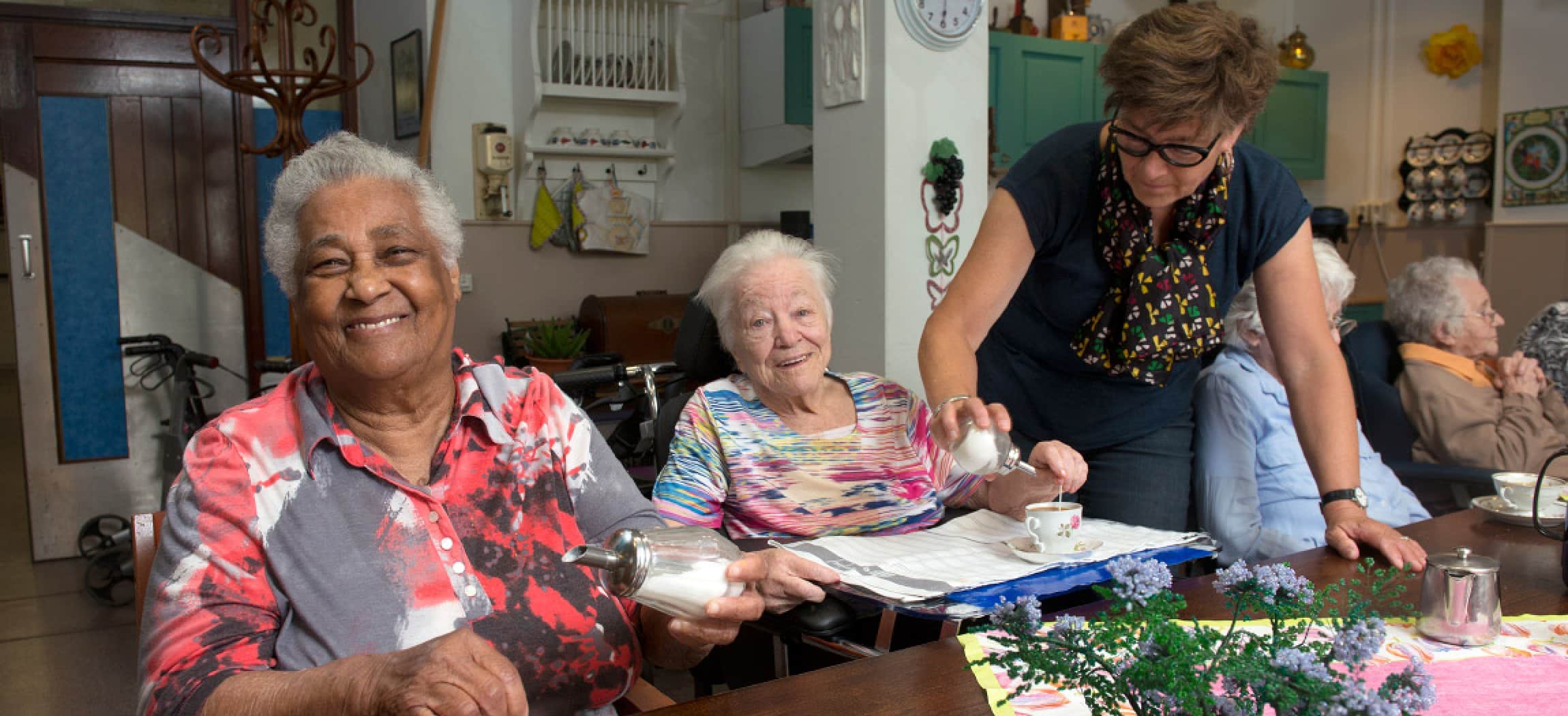 Lieve oude vrouwen aan gezellige tafel met koffie en knutselwerk