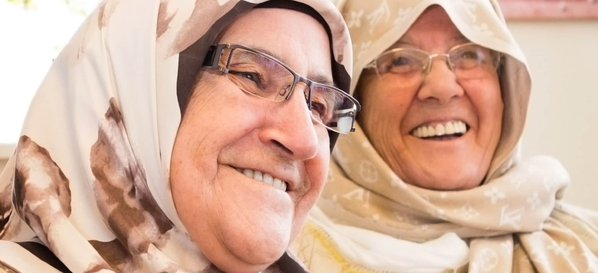 Twee vrolijke oudere dames met hoofddoek, omslagdoek of hijab