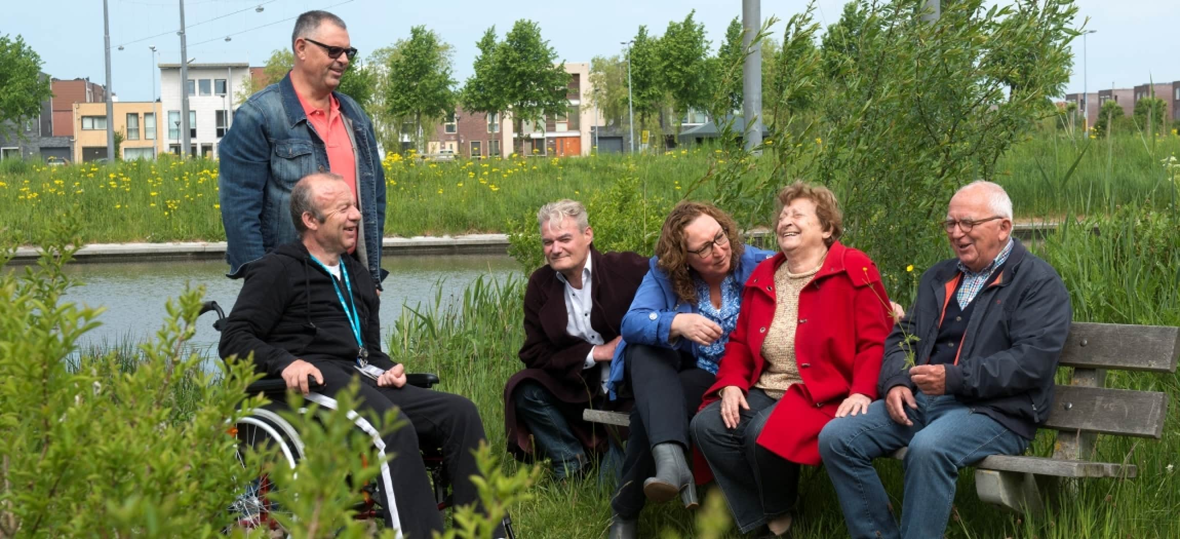 Ouderen zitten gezellig op een bankje in de groene natuur met meertje in Hoofddorp