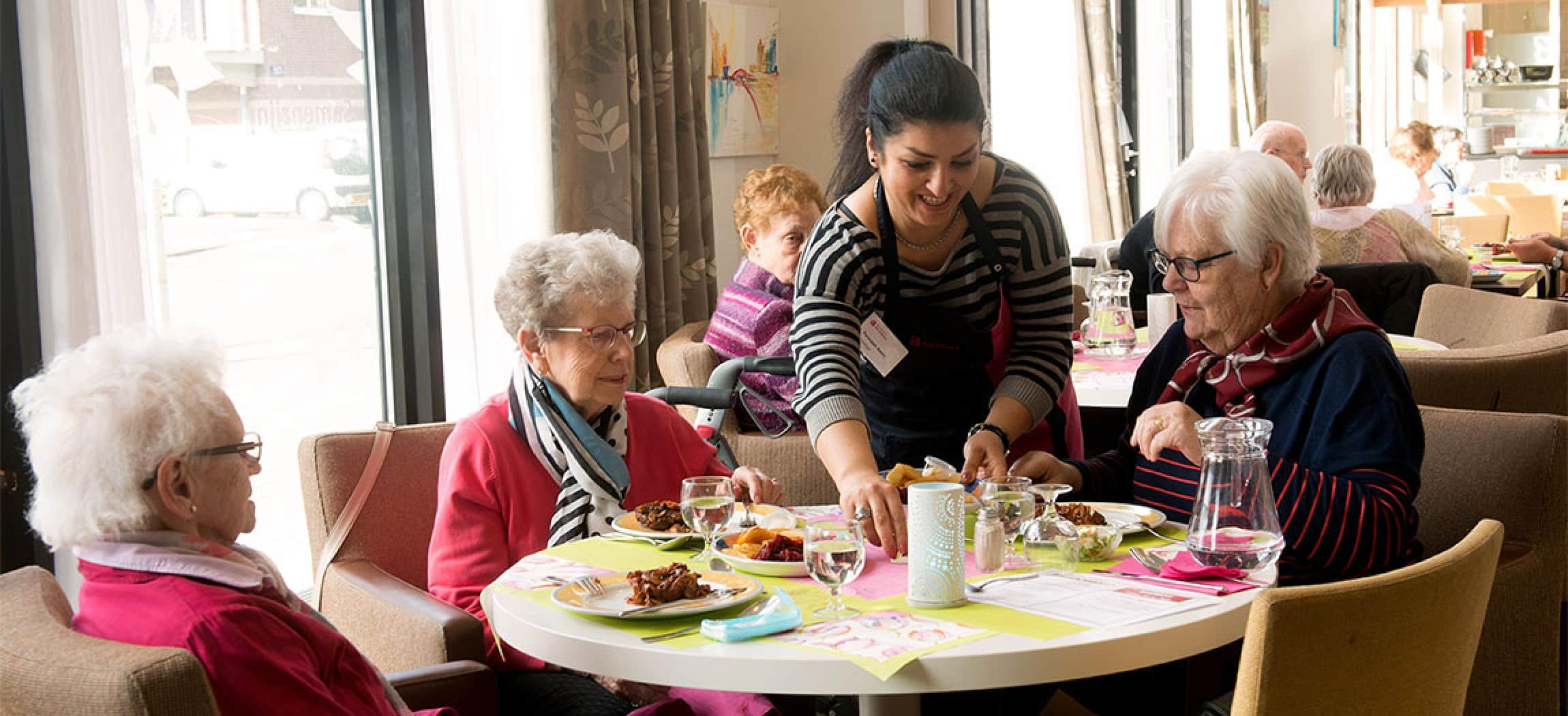 Drie oudere vrouwen eten samen in restaurant