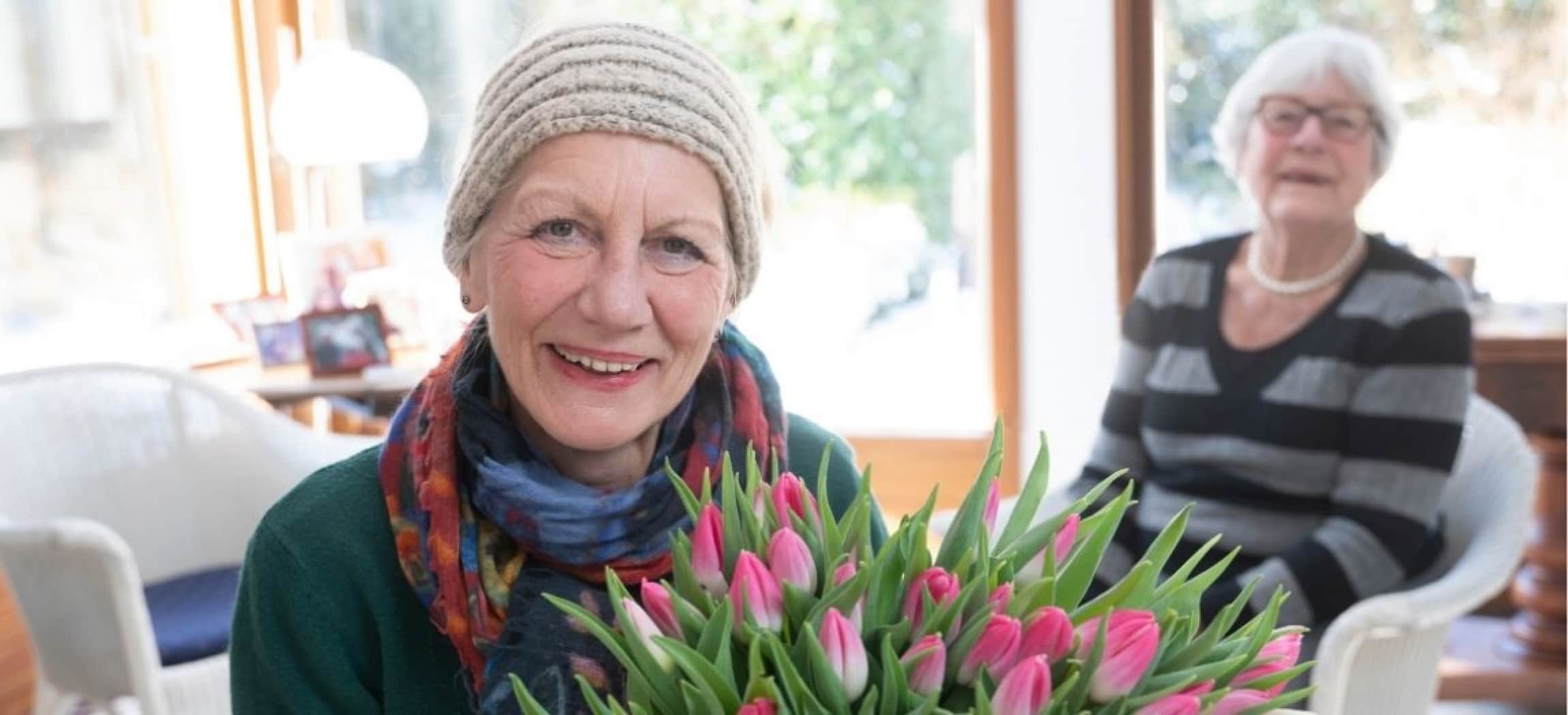 Manja Bunschoten van Amstelring Wijkzorg met een bos tulpen in haar handen