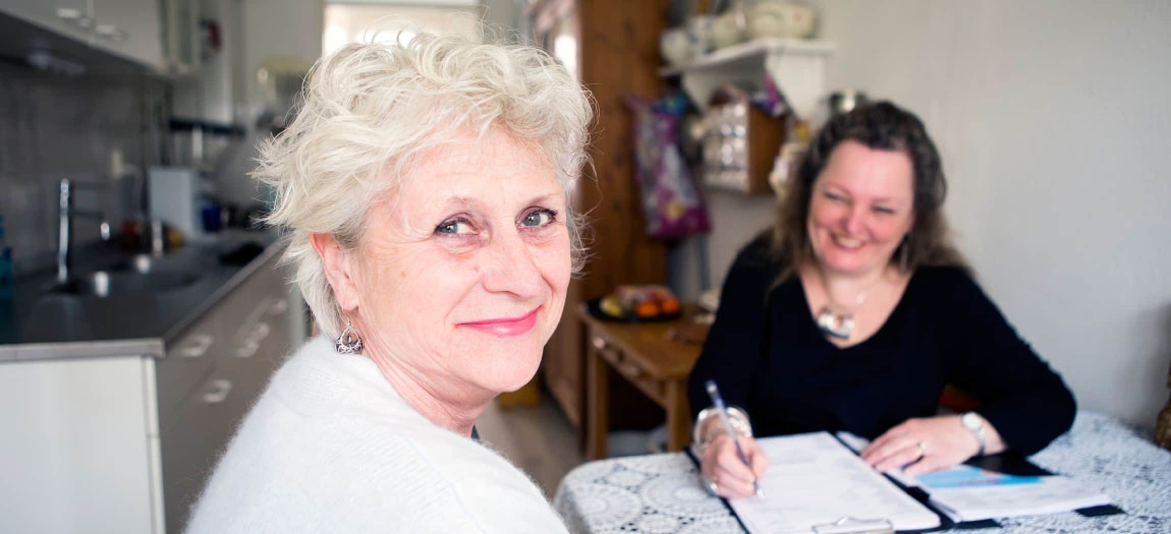 Lieve oude dame met witte pluizige trui kijkt vrolijk achterom