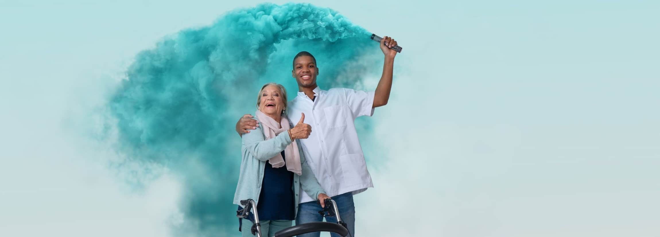 Mannelijke verzorgende met getinte huidskleur omarmt een oudere vrouw en houdt fakkel blauwe rook vast