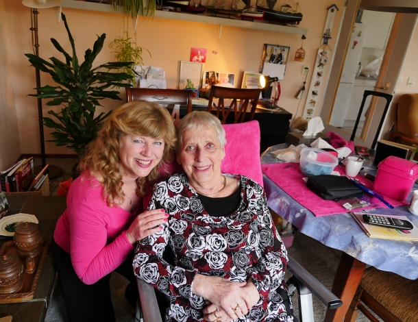 In gezellige woonkamer twee vrouwen met roze spullen schoonheidsbehandeling op tafel