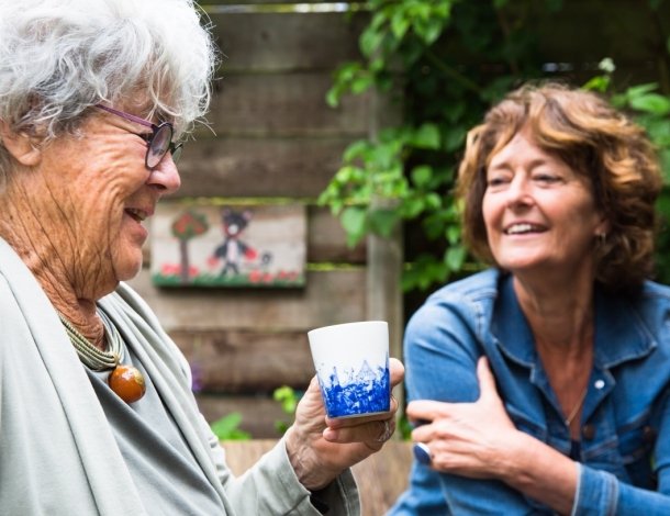 Twee oudere vrouwen in keuken met witte blouses