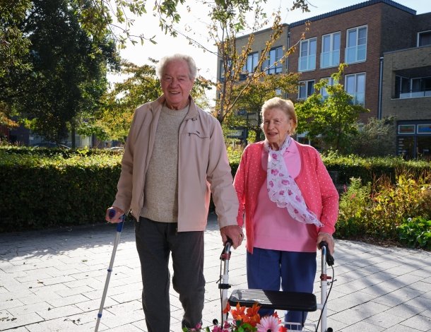 Mooie oudere blije vrouw aait haar oranje witte kat op tafel