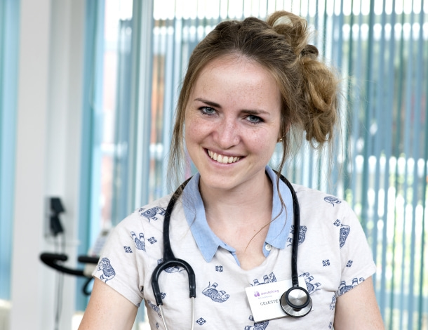 Arts jonge vrouw met stethoscoop en opgestoken haar, in opleiding tot Specialist Ouderengeneeskunde SOG